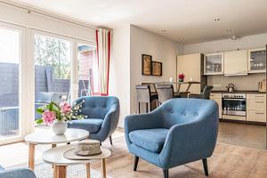 uma sala de estar com duas cadeiras azuis e uma mesa em fewo1846 - Schotstek - komfortable 2-Zimmer-Wohnung mit Terrasse em Harrislee