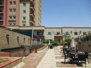 a patio with tables and chairs in front of a building at Frank Porter - Imperial in Dubai