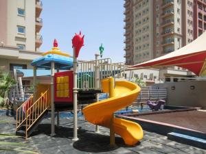 un parque infantil con tobogán y sombrilla en Frank Porter - Imperial en Dubái