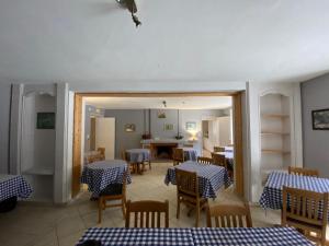 ein Restaurant mit blauen und weißen Tischen und Stühlen in der Unterkunft Chez Hervé le Châtelet in La Chaux Neuve