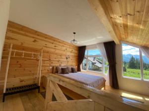 a bedroom with a bed and a large window at Sumska bajka in Žabljak