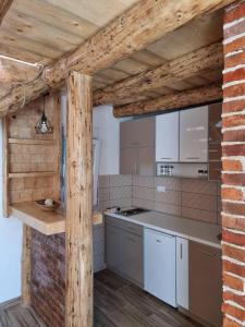 a kitchen with white appliances and a brick wall at Sumska bajka in Žabljak
