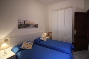 sypialnia z 2 łóżkami i niebieską pościelą w obiekcie Casa Mira con piscina e bellissima vista mare w mieście Costa Paradiso