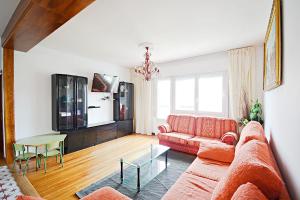 sala de estar con sofá rojo y mesa en Espacioso apartamento en Cambados, en Cambados