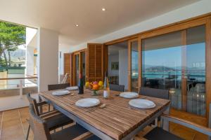 a wooden table in a dining room with a view at Ed Bellveure 2 A in Port de Pollensa