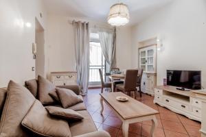 salon z kanapą, telewizorem i stołem w obiekcie When in Trastevere w Rzymie