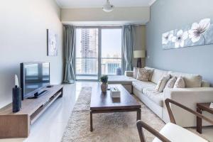 a living room with a couch and a tv at Frank Porter - Ocean Heights in Dubai