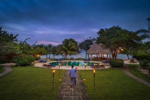 un uomo che cammina lungo un sentiero verso una piscina di Turtle Inn by Francis Ford Coppola a Placencia