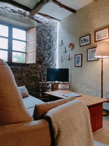 uma sala de estar com um sofá e uma mesa em La Cabana´l Cachican em Cangas del Narcea