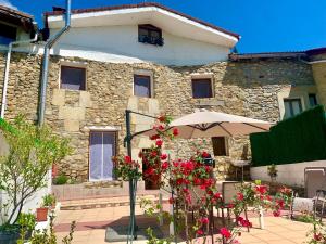 a stone house with flowers in front of it at Casa Hijuela in Concejero