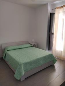 ノートにあるPerla del sudのベッドルーム1室(ベッド1台、緑の毛布付)