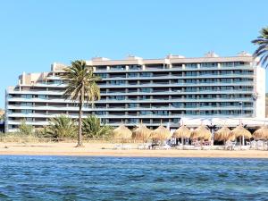 un hôtel sur la plage avec des chaises et des palmiers dans l'établissement Los Flamencos Sea View Apartment, à Carthagène