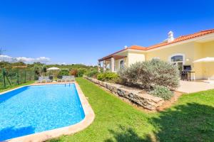 a villa with a swimming pool and a house at Eden Resort in Albufeira