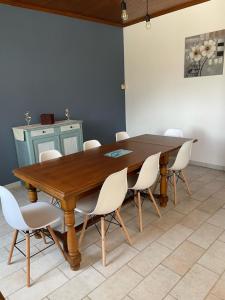 une salle à manger avec une table en bois et des chaises blanches dans l'établissement Gîte à la campagne 6-8 personnes, à Mialet