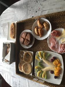 una mesa cubierta con platos de pan y fruta en Casa Rural Paloma, en Benajarafe