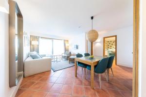 a dining room and living room with a table and chairs at The Patio Suite Hotel in Albufeira