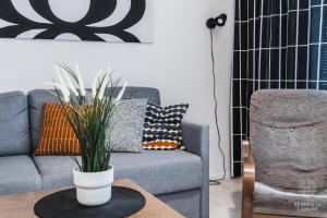 a living room with a couch and a table with a plant at Holiday In Lapland - LeviStar II 312 in Levi +22 photos