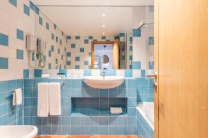a bathroom with blue and white tiled walls and a sink at The Patio Suite Hotel in Albufeira