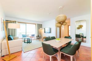 a dining room and living room with a table and chairs at The Patio Suite Hotel in Albufeira
