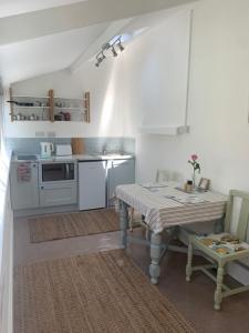 a kitchen with a table and a kitchen with a stove at Puffin. Comfortable Annexe Central Falmouth in Falmouth