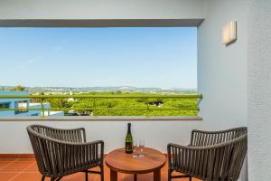 two chairs and a table with a bottle of wine on a balcony at The Patio Suite Hotel in Albufeira