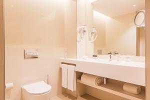 a white bathroom with a sink and a toilet at The Patio Suite Hotel in Albufeira