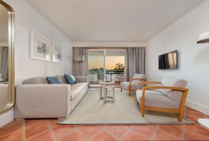 a living room with a couch and a table and chairs at The Patio Suite Hotel in Albufeira