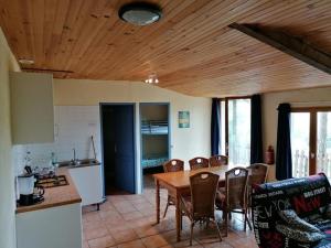 - une cuisine et une salle à manger avec une table et des chaises dans l'établissement Gîte en pleine nature proche du lac de la Gimone, à Saint-Blancard