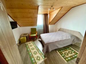 1 dormitorio con cama y techo de madera en Casa Mis, en Baia de Fier