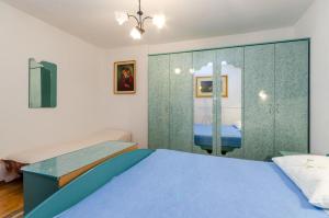 a bedroom with a blue bed and a glass wall at TOMIC A MAZURANICA in Novi Vinodolski