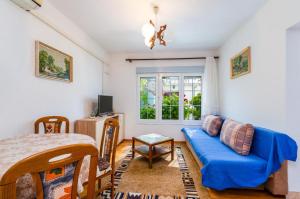 a living room with a blue couch and a window at TOMIC A MAZURANICA in Novi Vinodolski