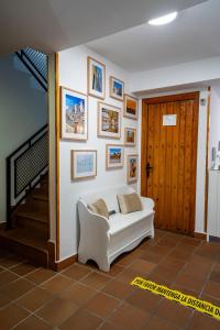 een woonkamer met een witte bank en foto's aan de muur bij Hostal Plaza de Italia in Cáceres