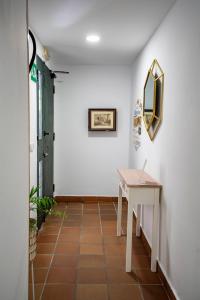 a hallway with a white table and a mirror at Hostal Plaza de Italia in Cáceres