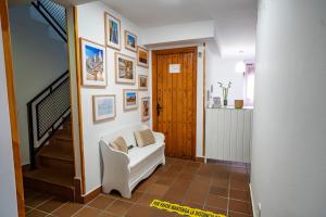 a living room with a white couch and pictures on the wall at Hostal Plaza de Italia in Cáceres