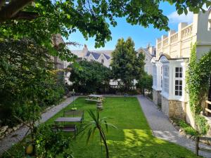 einen Innenhof eines Hauses mit Bänken und Bäumen in der Unterkunft The Chelsea in Llandudno