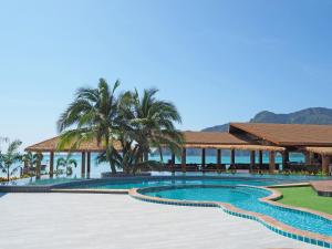 una piscina in un resort con palme e oceano di Phi Phi Andaman Beach Resort a Phi Phi Don