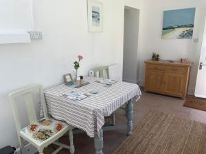 a dining room table with two chairs and a striped table at Puffin. Comfortable Annexe Central Falmouth in Falmouth