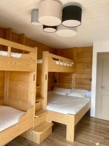 2 Etagenbetten in einem Zimmer mit einer Decke in der Unterkunft Appartement tout confort in Champoussin