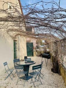 taras ze stołem i krzesłami obok budynku w obiekcie Maison entière aux portes du canal de Bourgogne w mieście Pouilly-en-Auxois
