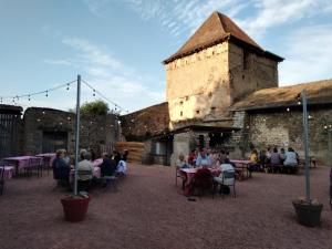 een groep mensen die aan tafels voor een gebouw zitten bij Château de Gorze in Germolles-sur-Grosne