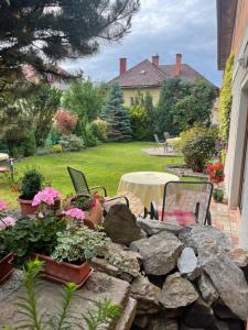 un jardín con una pared de roca y una mesa con flores en Hotel Garni Expo, en Banská Bystrica