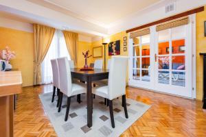 a dining room with a table and white chairs at Apartments Villa Rossella 1 in Rovinj