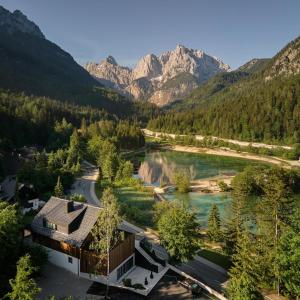 una vista aerea di una casa con un fiume e le montagne di Milka Boutique Hotel a Kranjska Gora