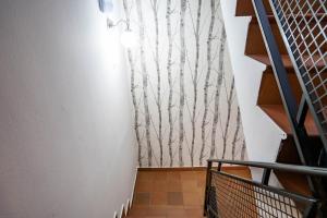 a staircase with a wall mural of trees at Hostal Plaza de Italia in Cáceres