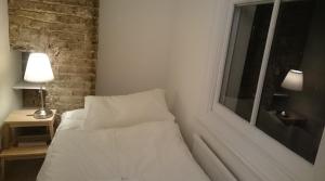 a white bed in a room with a window at Central London flat. Georgian Terrace. Bright. in London