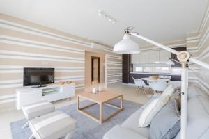 a living room with a couch and a tv at Laguna - Vilamoura in Vilamoura