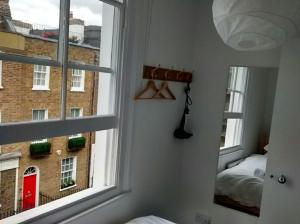 a room with two windows and a bedroom with a bed at Central London flat. Georgian Terrace. Bright. in London