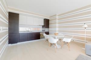 a kitchen with a white table and white chairs at Laguna - Vilamoura in Vilamoura