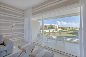 a living room with a large window with a table and chairs at Laguna - Vilamoura in Vilamoura