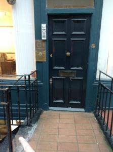 una puerta negra de un edificio con una acera de ladrillo en Central London flat. Georgian Terrace. Bright., en Londres